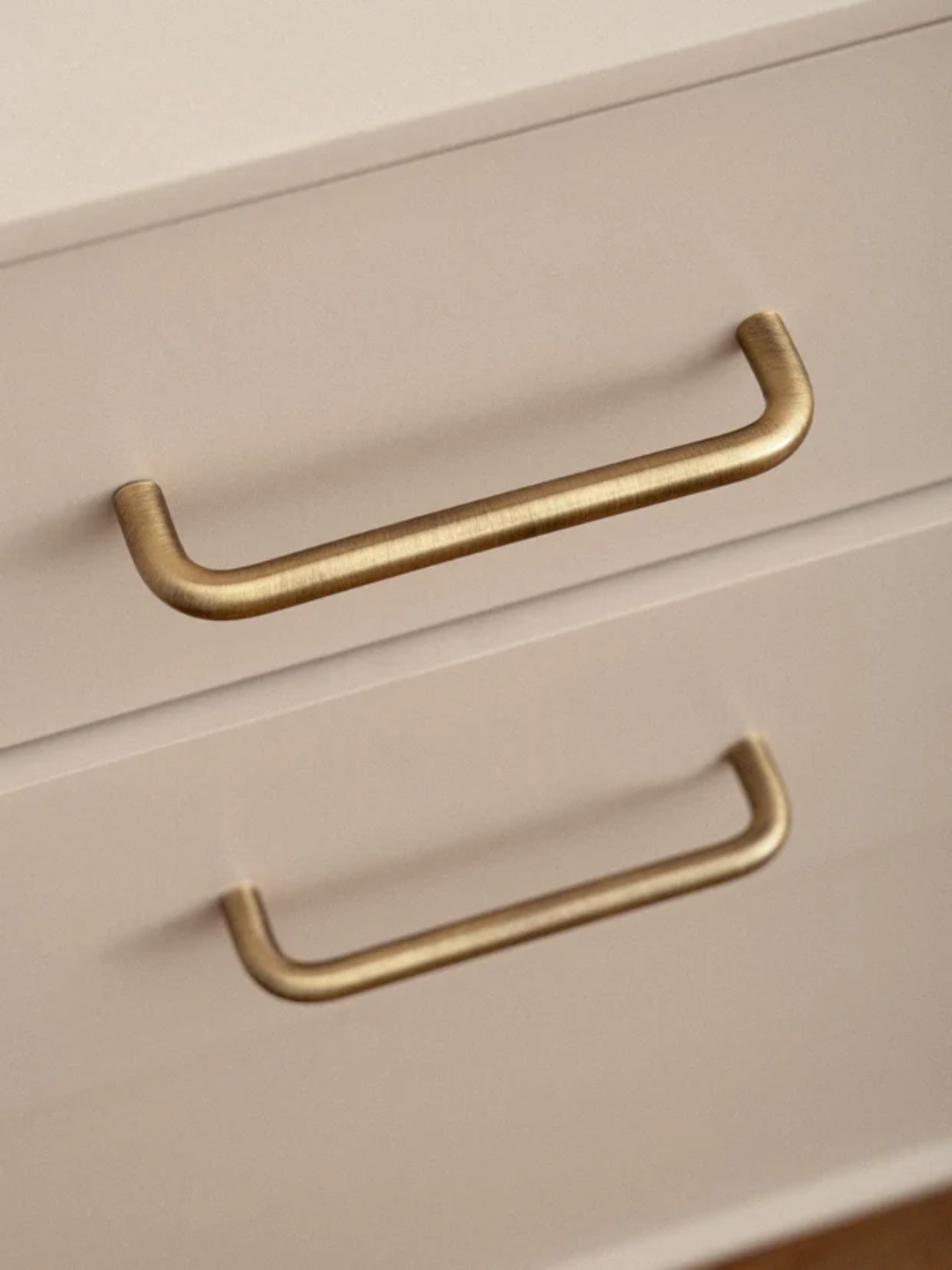 Close-up of beige drawers with gold handles