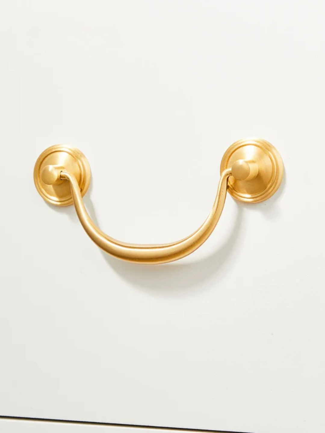 Gold cabinet handle on a white background