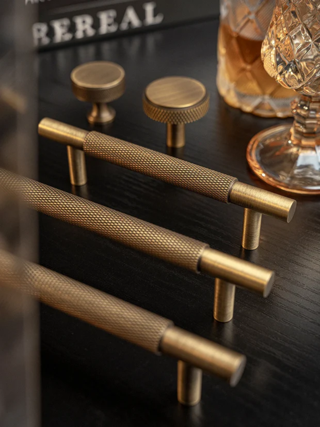 Three bronze cabinet knobs on a light background