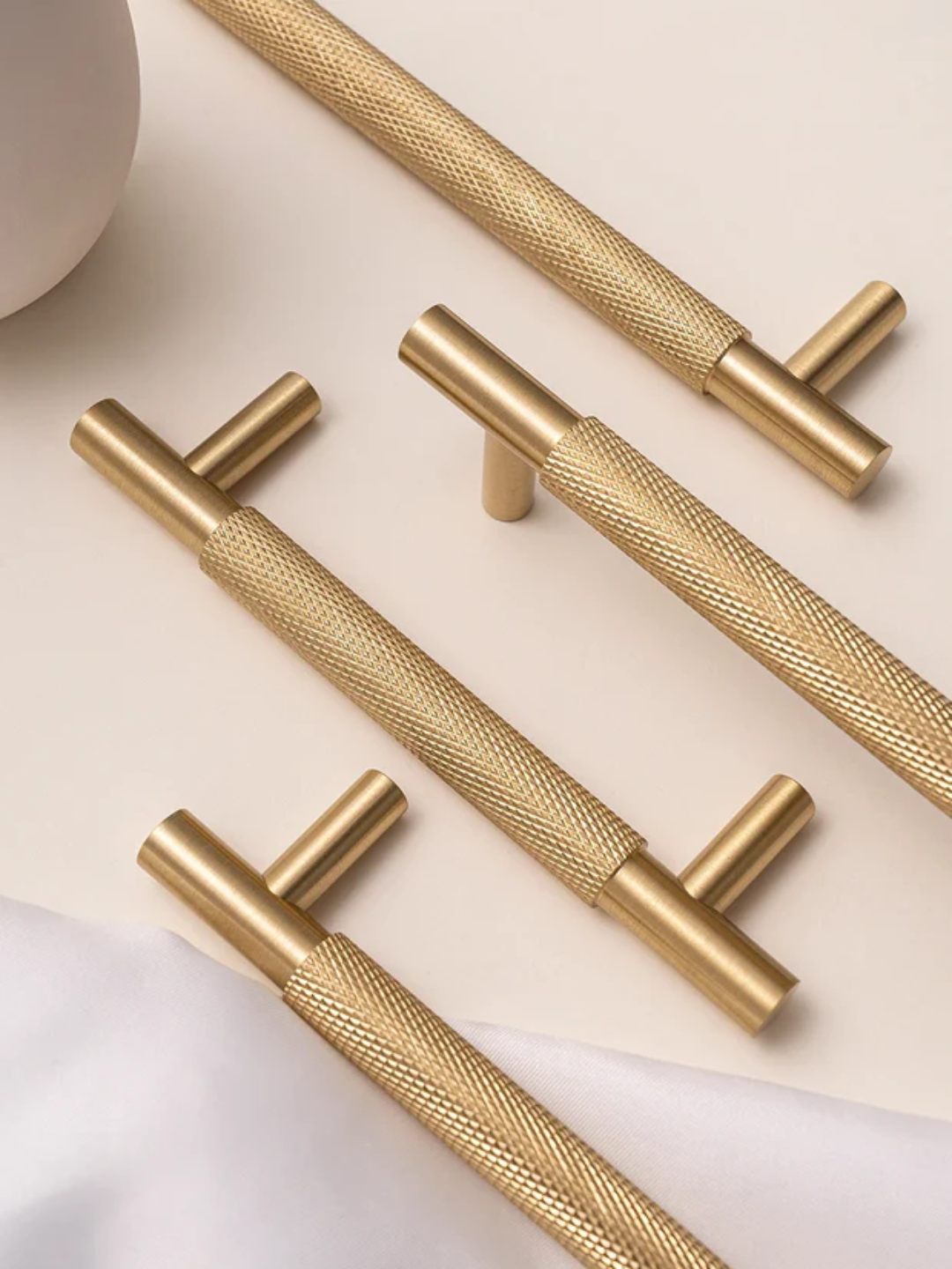 Gold cabinet handles on a light background