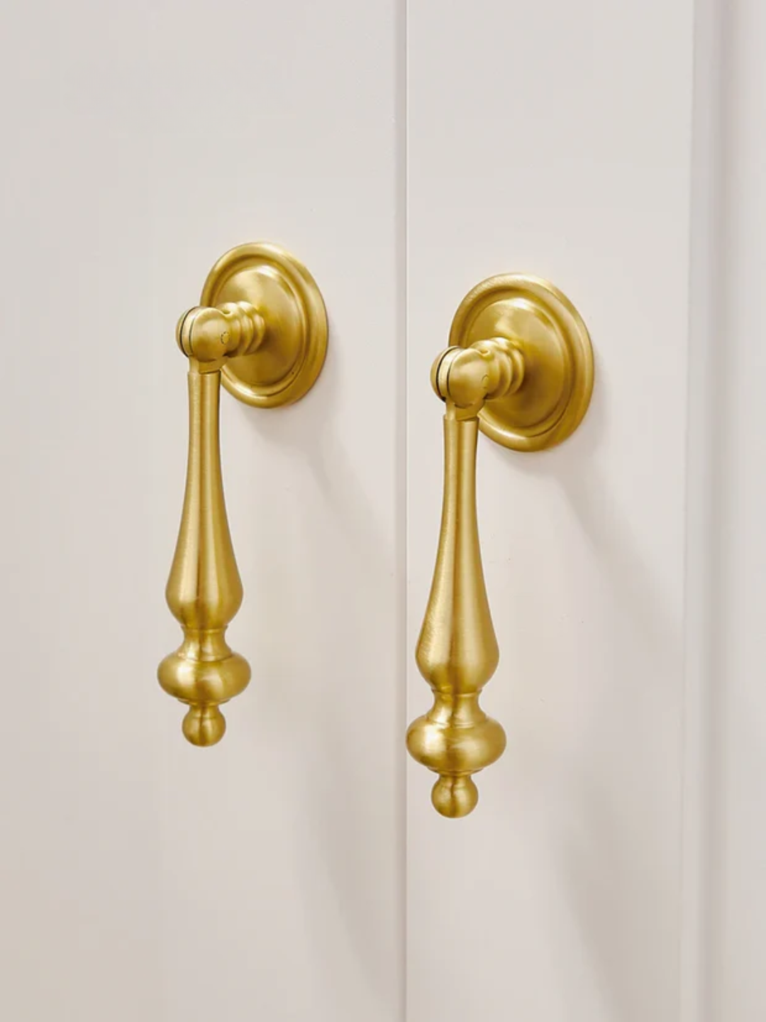 Pair of gold door handles on a white door