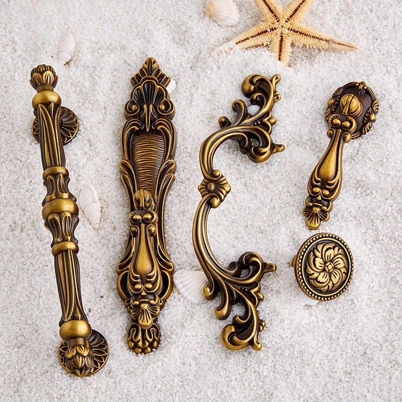 Decorative brass cabinet handles on a textured surface with a wooden background.
