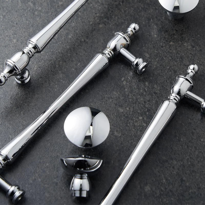 Collection of silver door handles and knobs on a dark surface