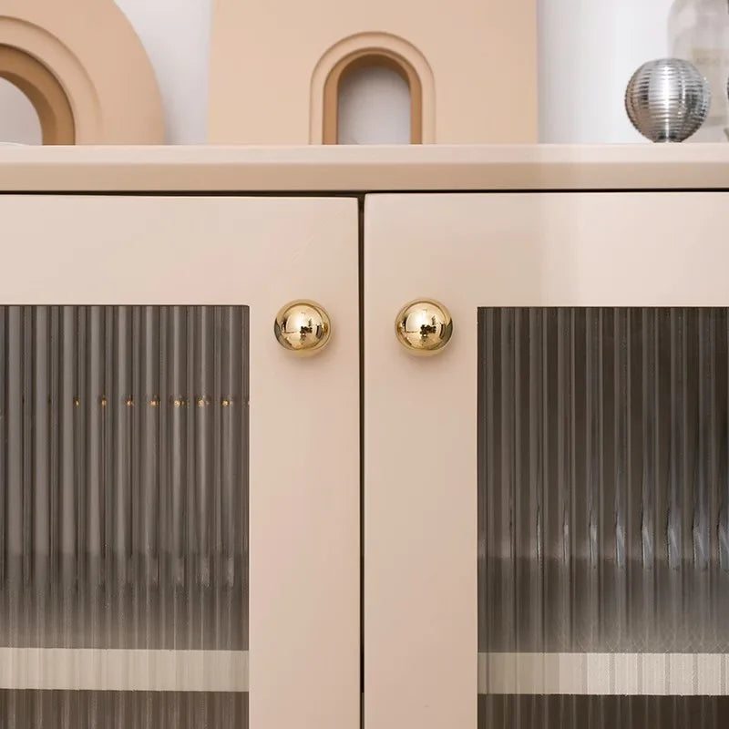 Beige cabinet with gold knobs and glass doors