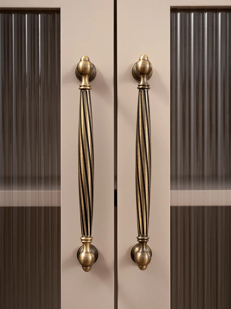 Pair of gold cabinet handles on a neutral background