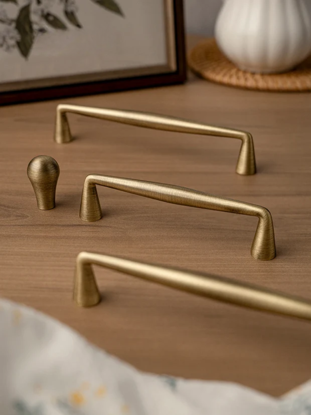 Set of gold cabinet handles on a wooden surface with a blurred background