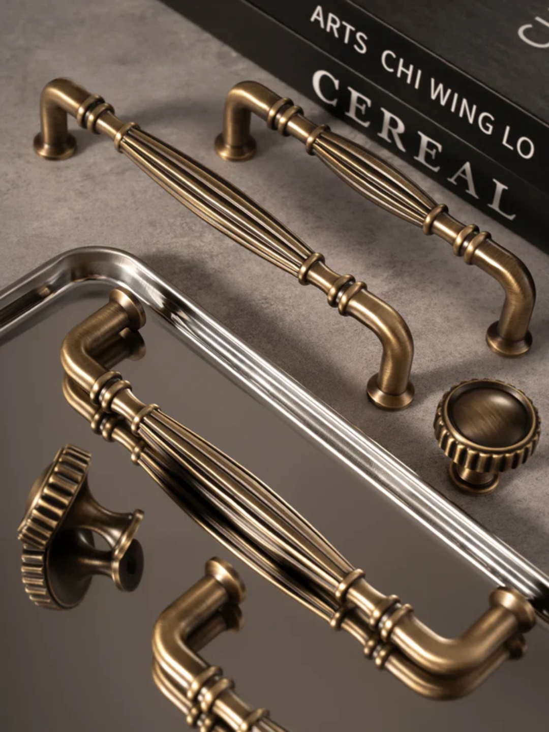 Bronze cabinet handles on a metallic tray with 'CEREAL' branding in the background.