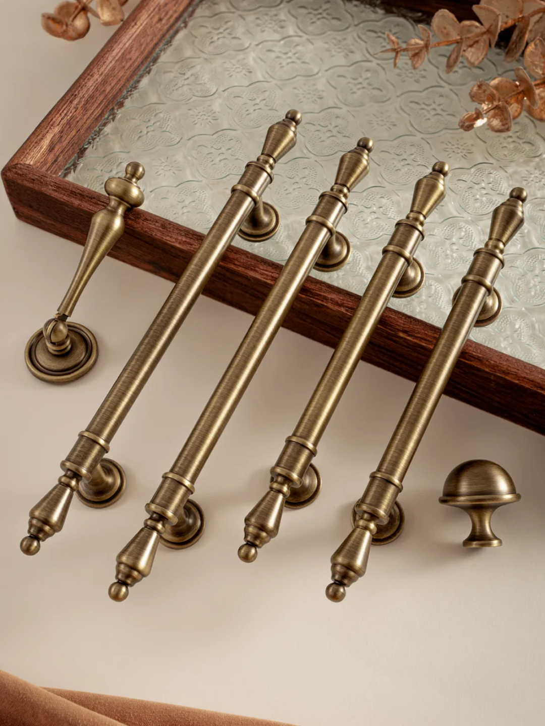 Set of vintage-style brass cabinet handles on a neutral background