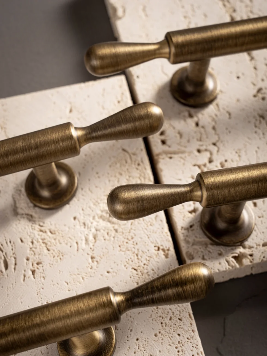 Close-up of brass cabinet handles on a textured surface