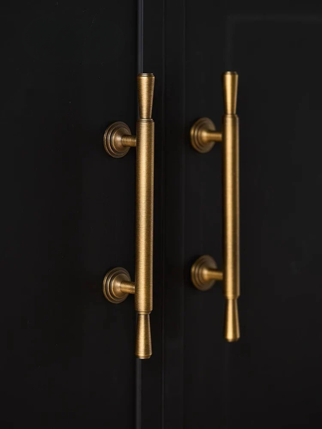 Gold door handles on a black door