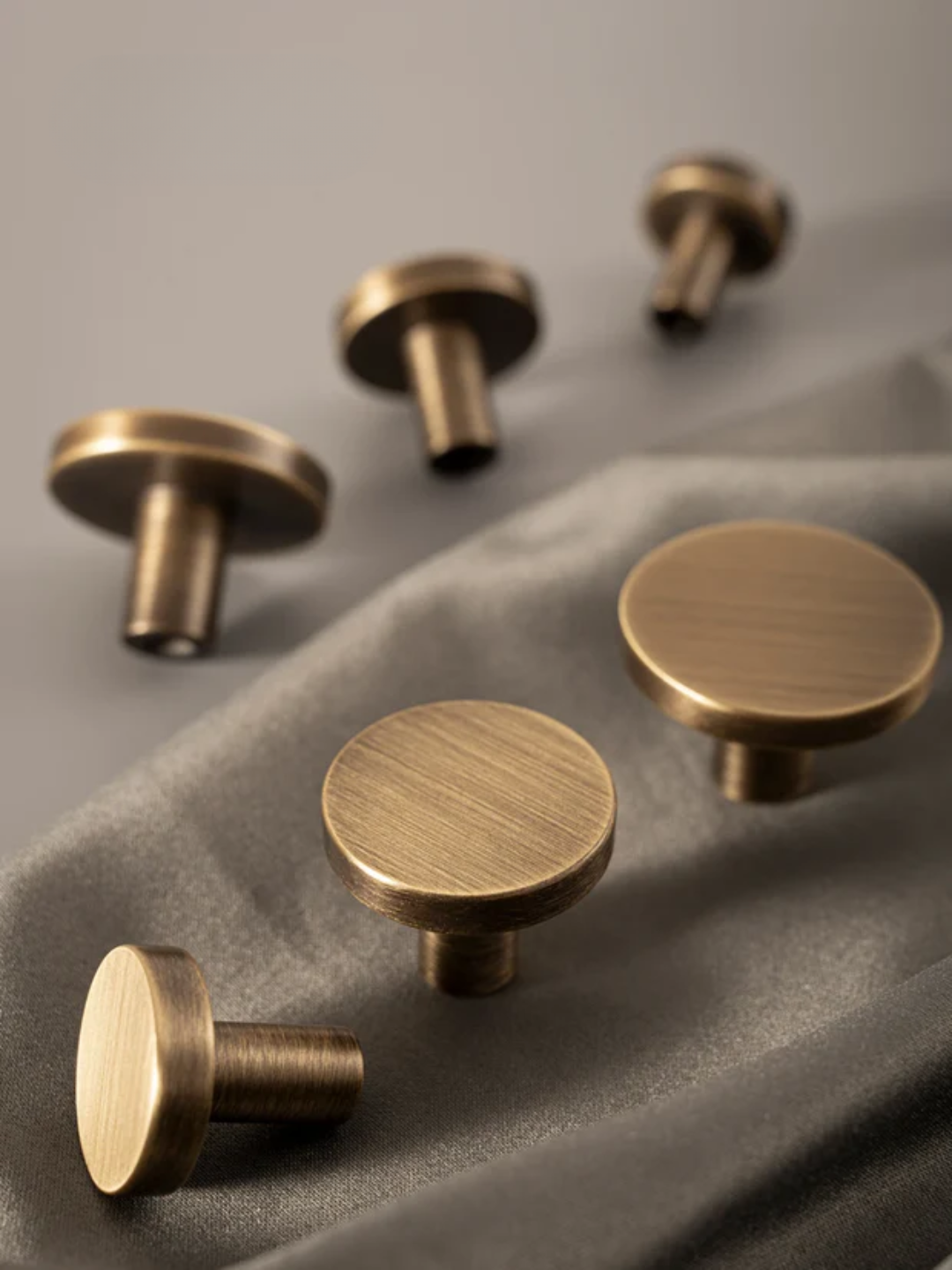 Set of bronze cabinet handles and knobs on a gray background