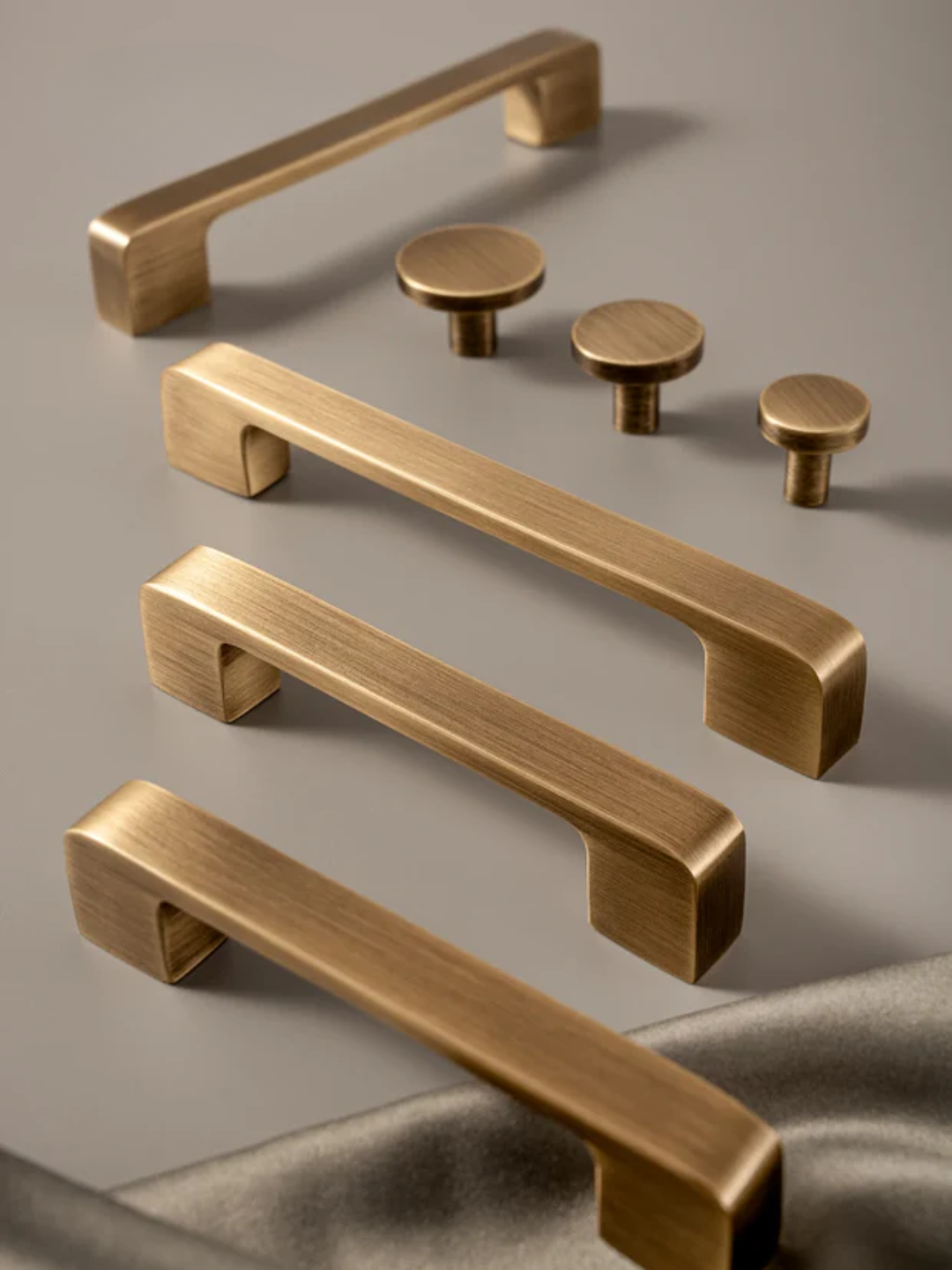 Set of bronze cabinet handles and knobs on a gray background