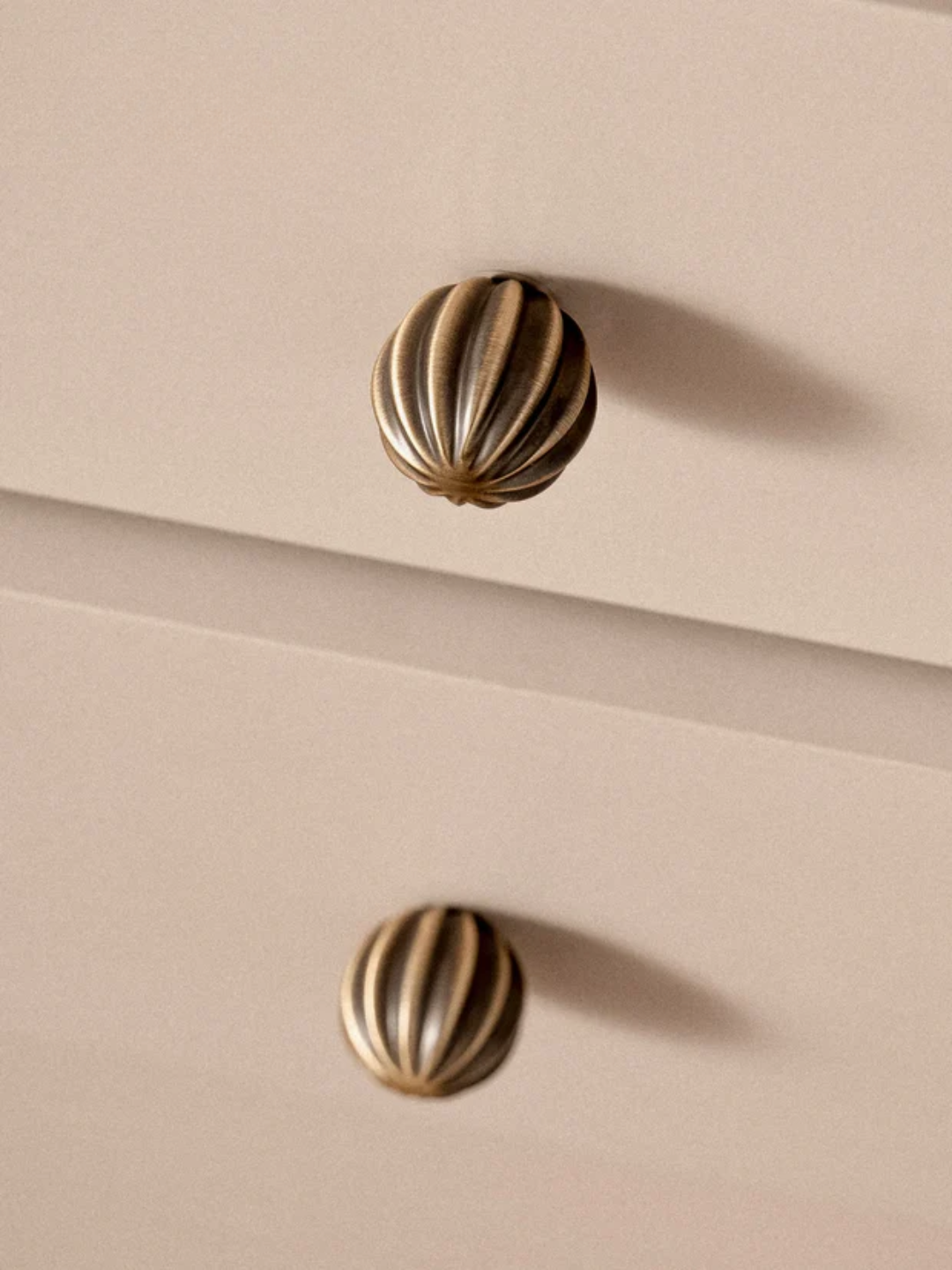 Decorative brass knobs on a beige surface