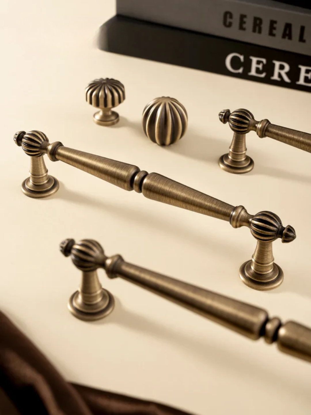 Bronze cabinet handles on a light background with 'SANTAYA' branding.