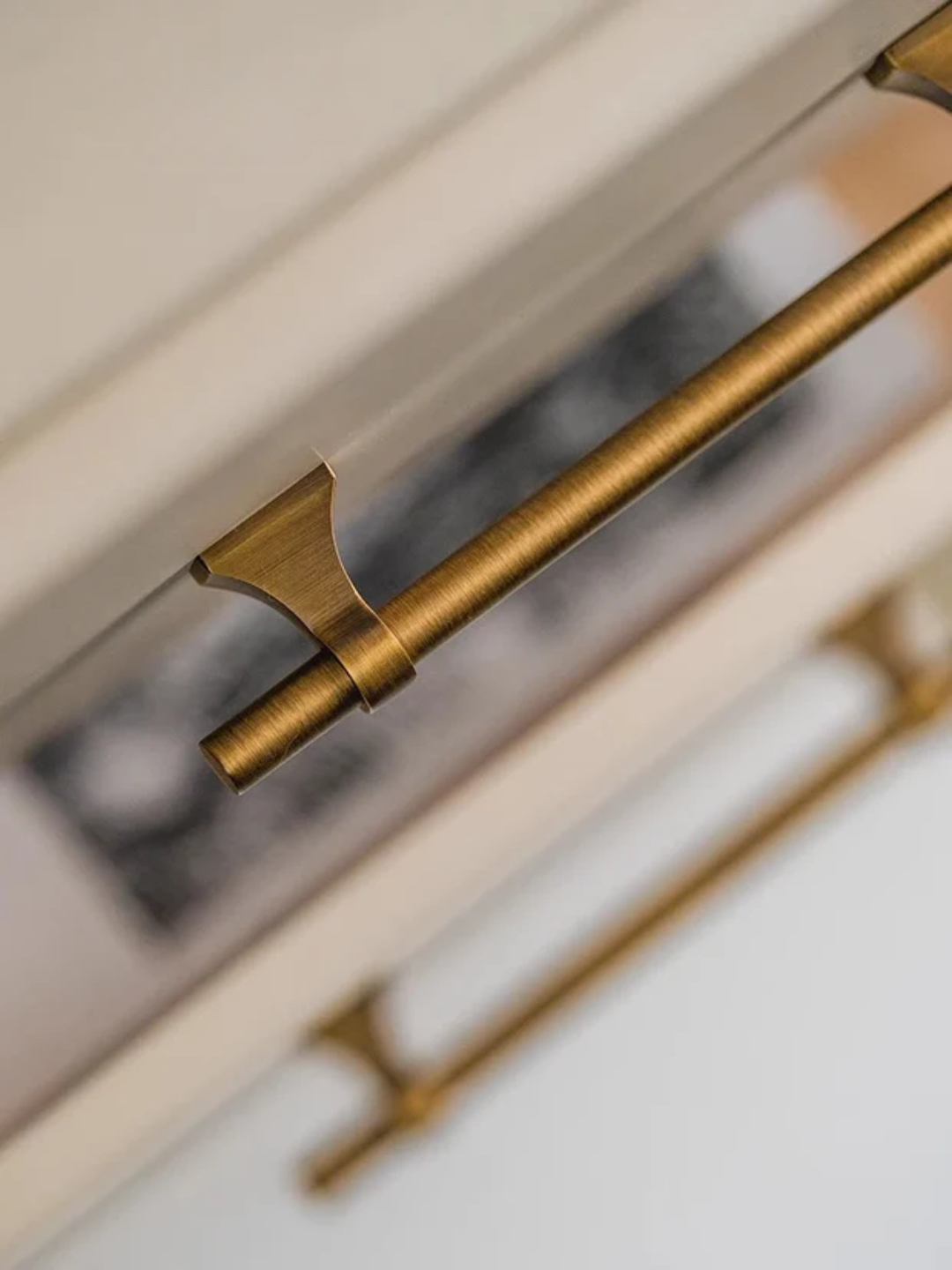 Close-up of a gold handle on a white cabinet