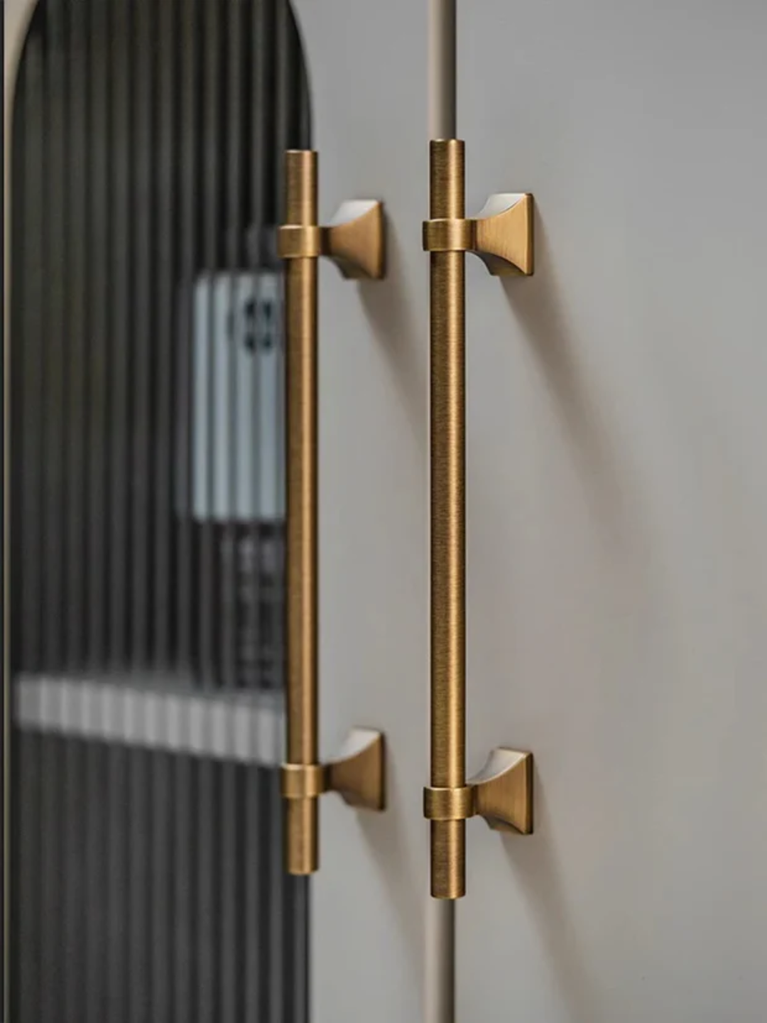 Gold door handles on a gray door with 'Santoma' branding.