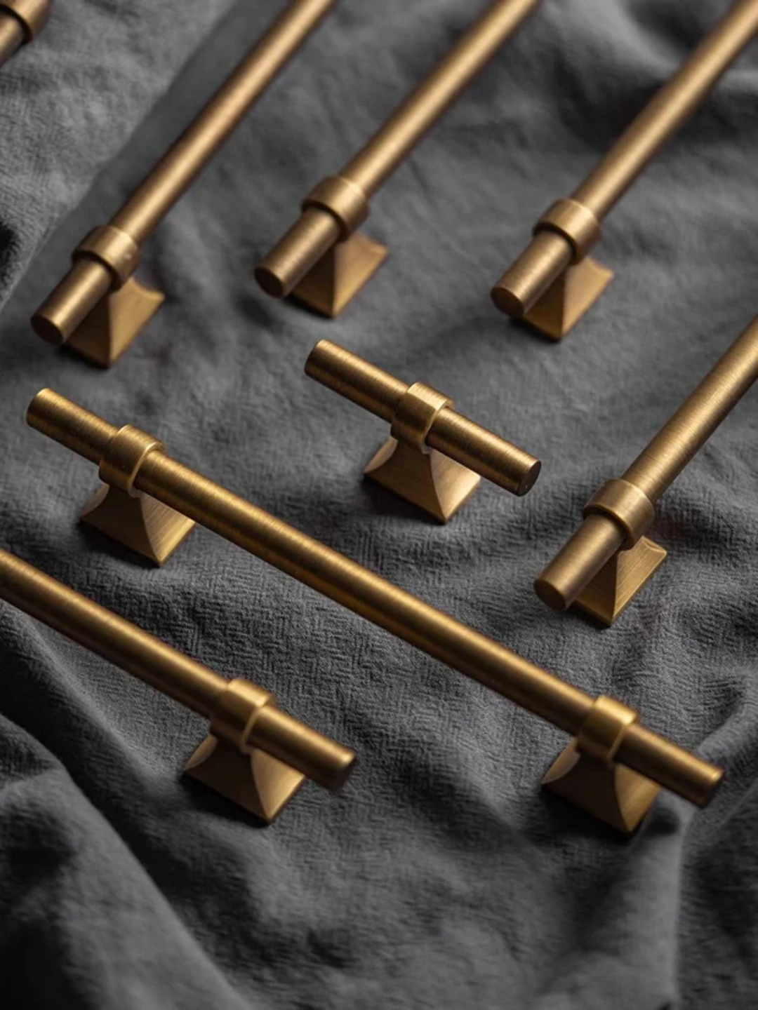 Gold cabinet handles on a dark fabric background