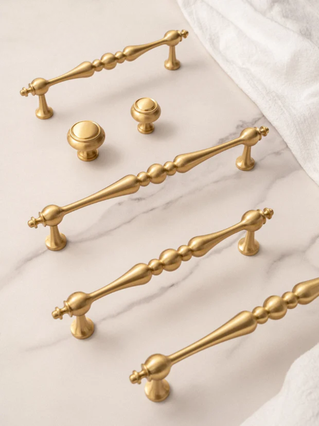 Gold cabinet handles on a marble surface