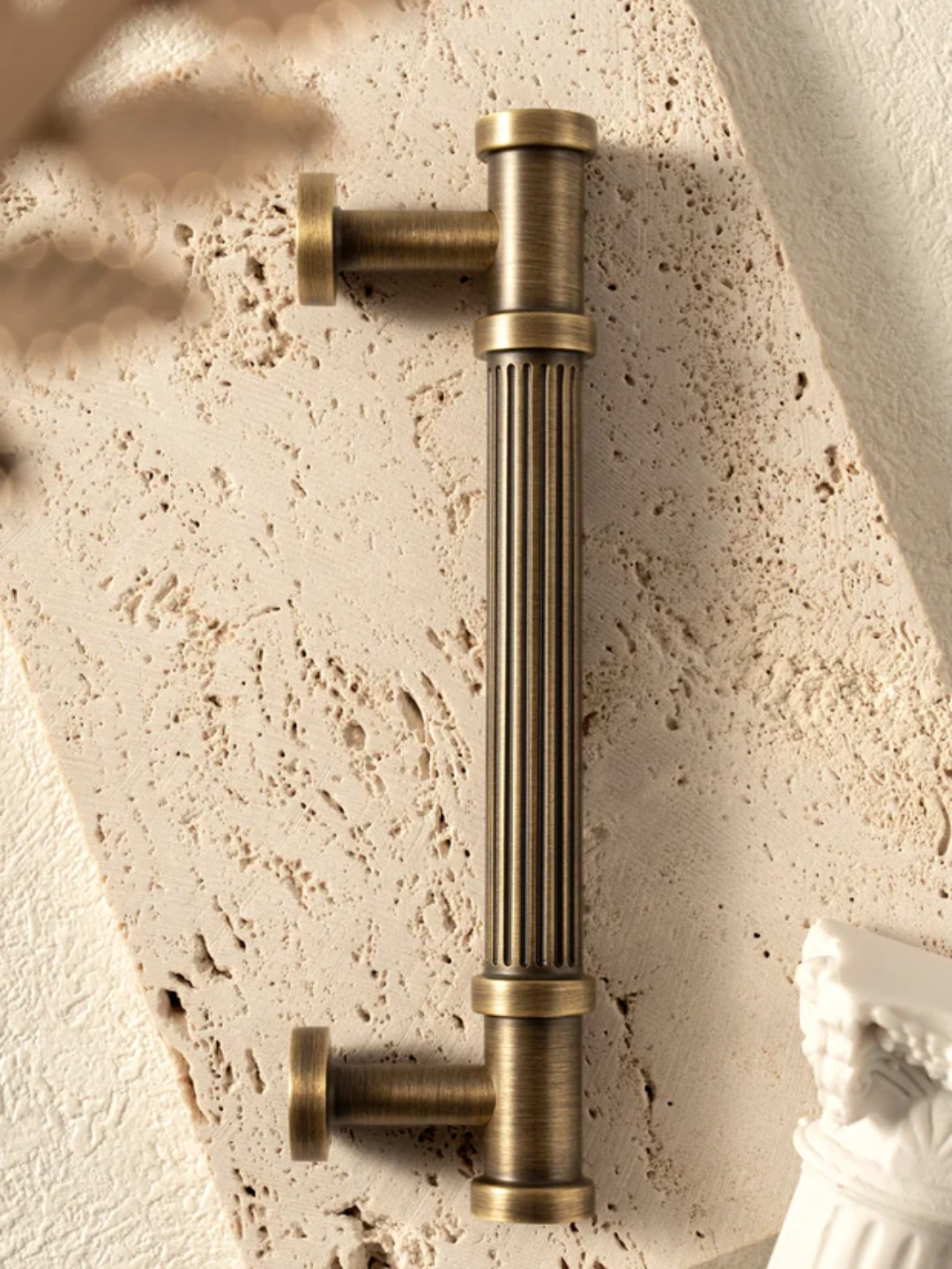 Brass cabinet handle on a textured wall