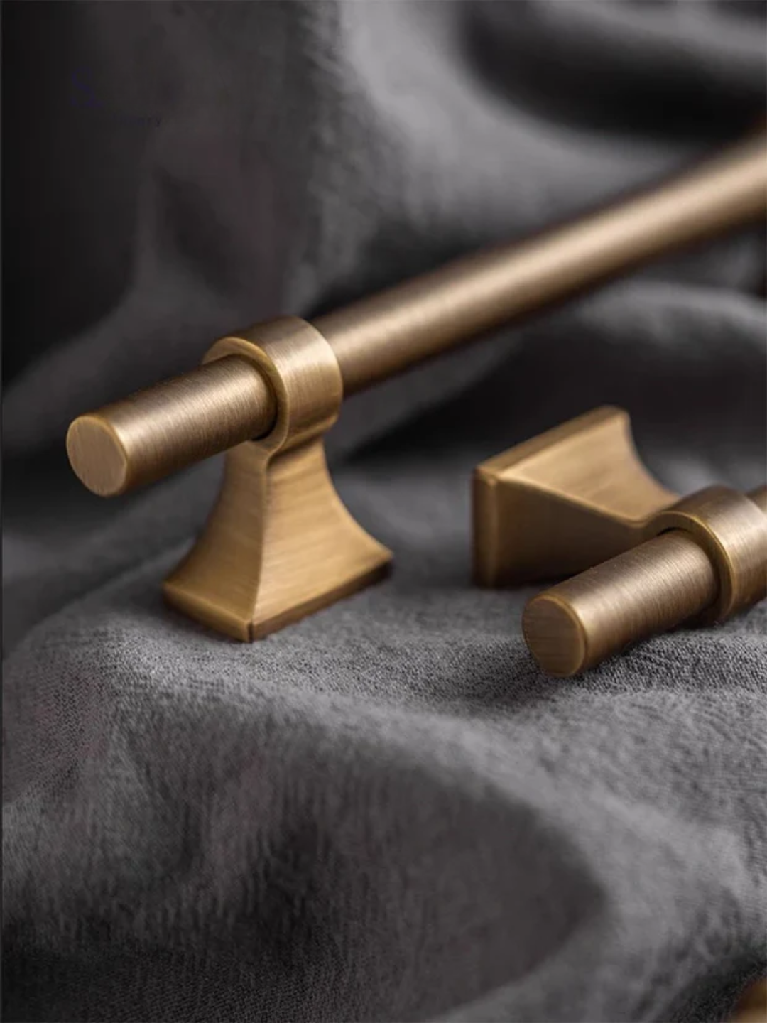 Brass curtain rod and finials on a textured gray background