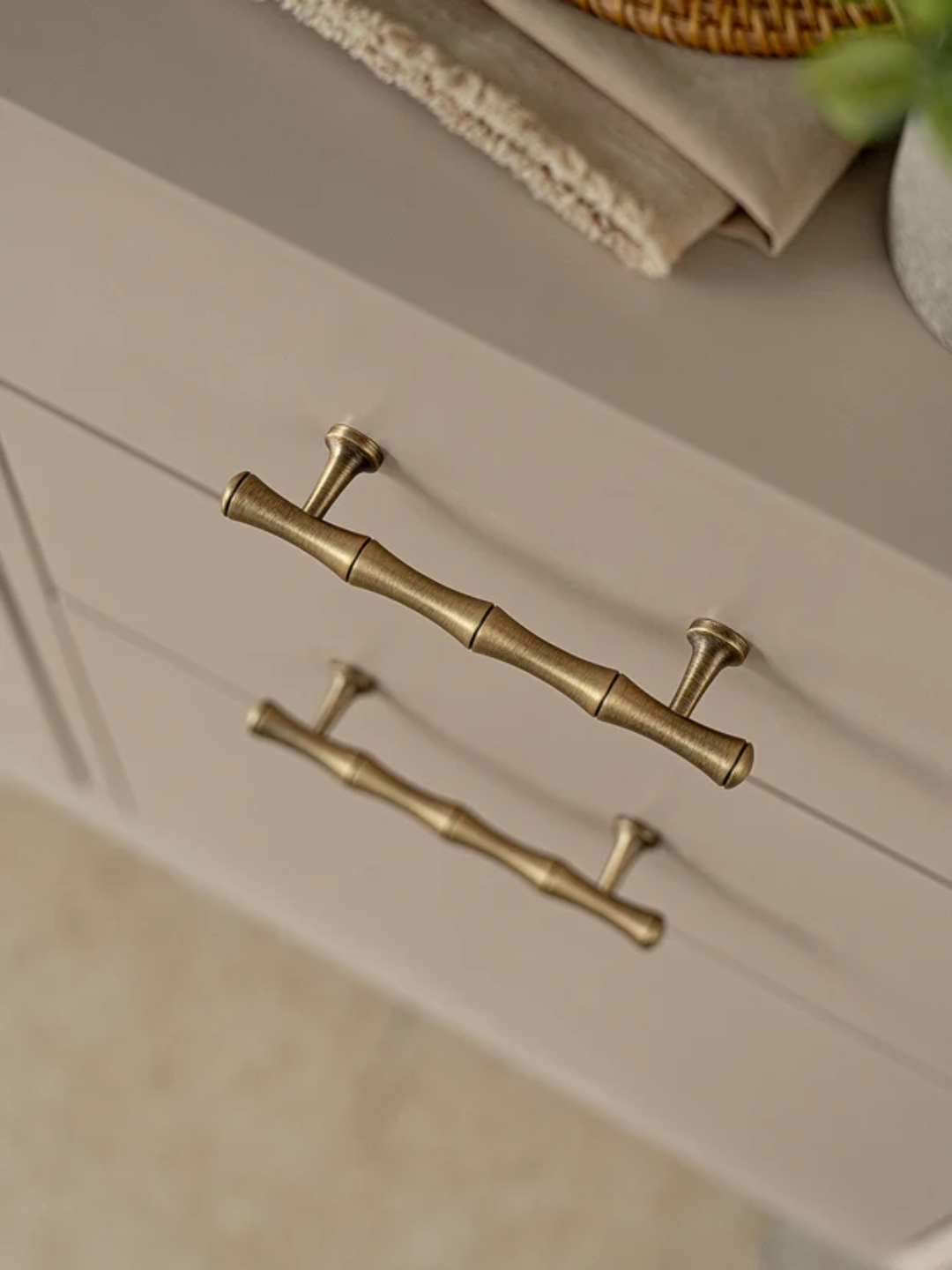 Close-up of a white cabinet with gold handles on a neutral background
