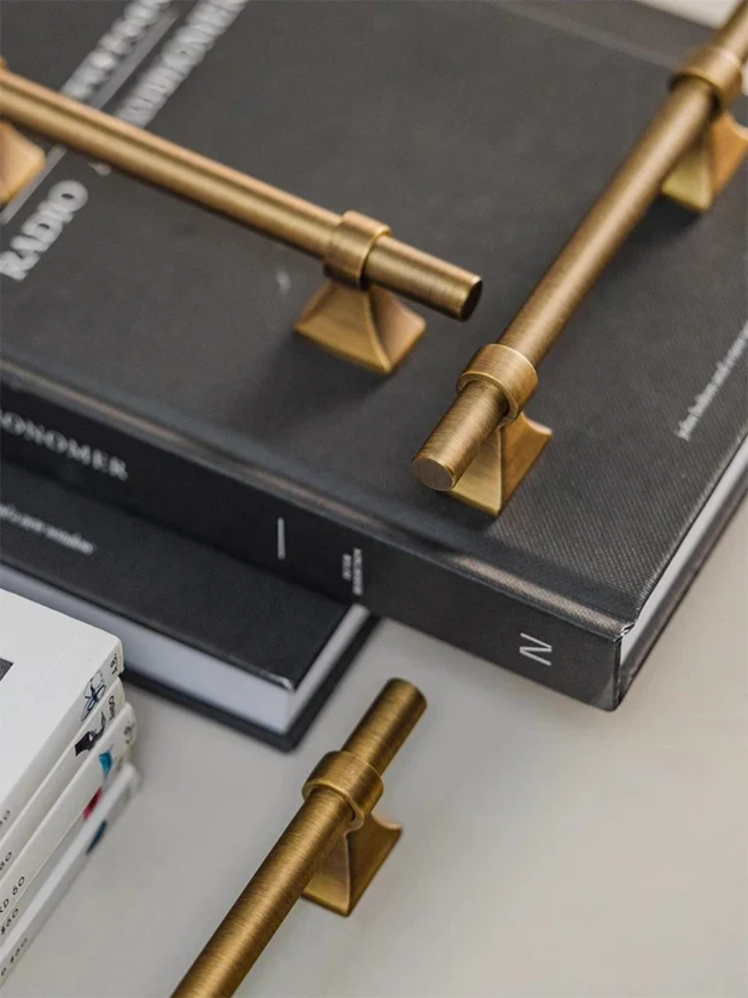 Gold cabinet handles on a black book with a blurred background