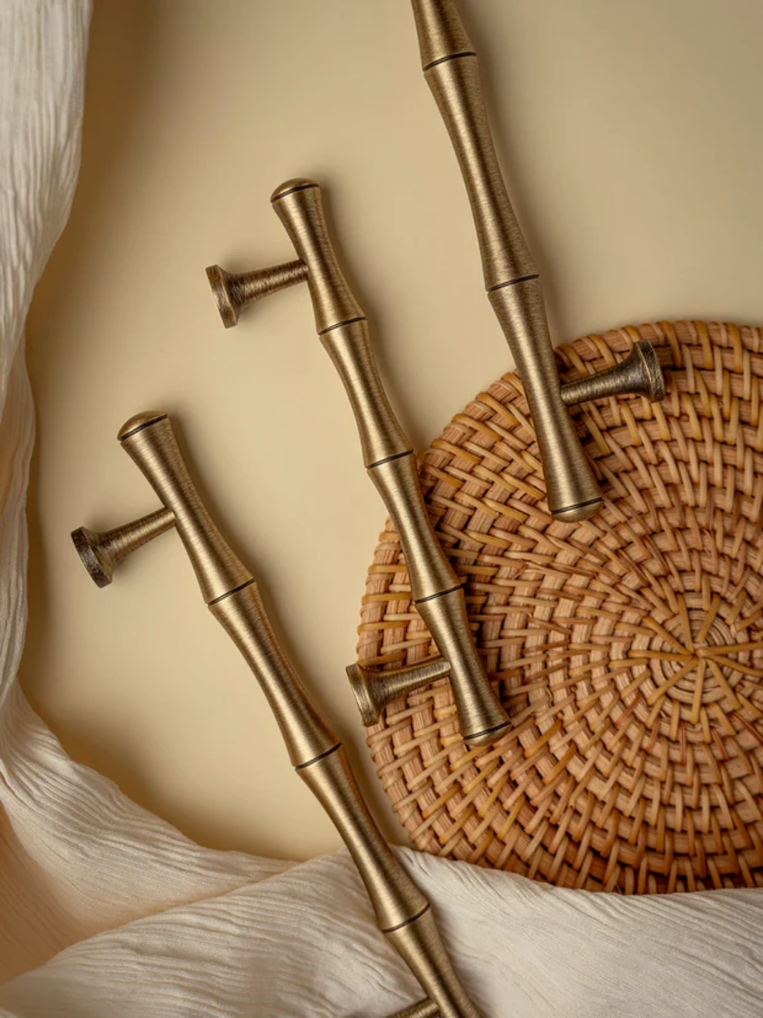 Set of gold kitchen faucets on a woven mat with a neutral background