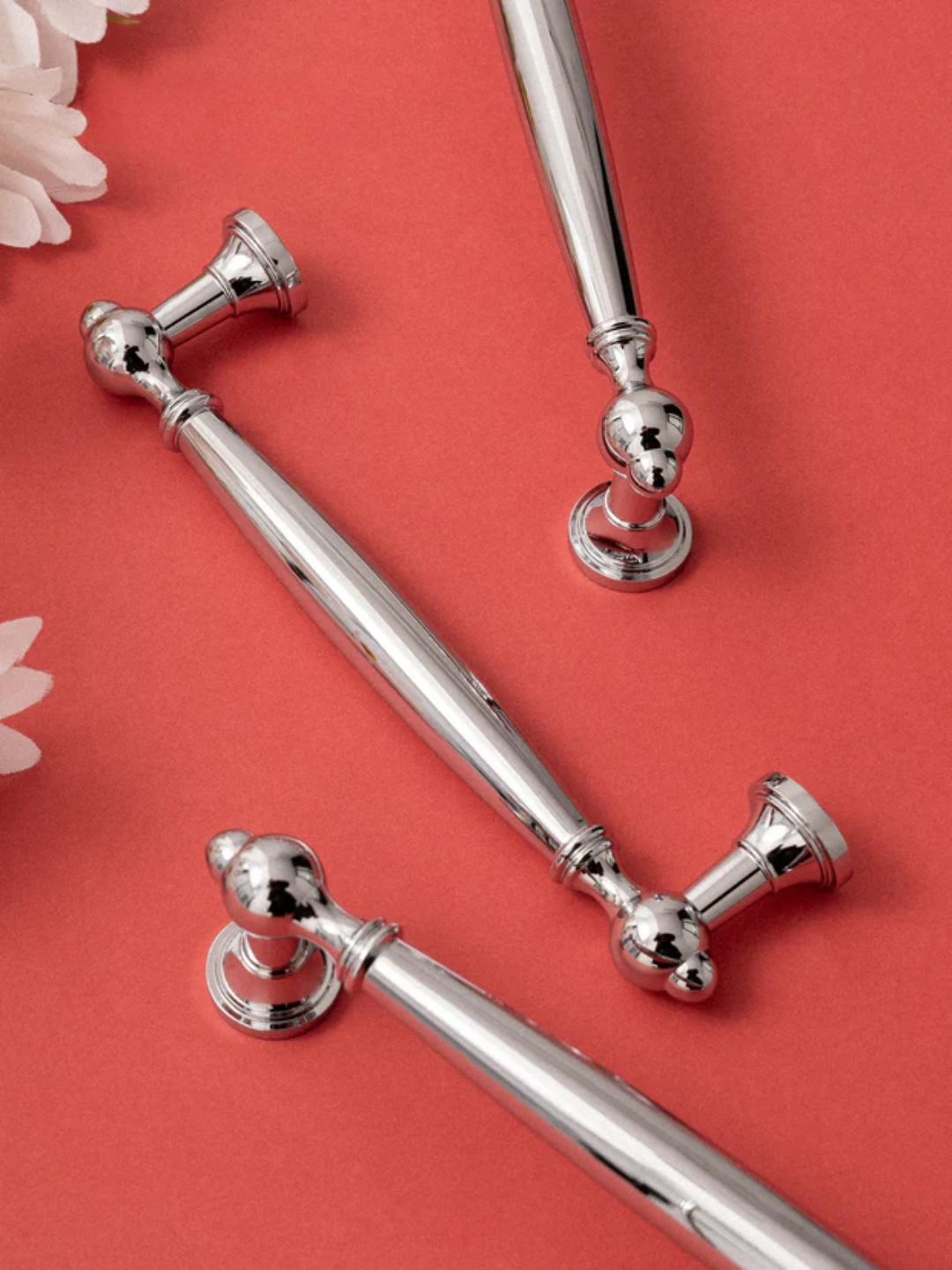 Silver decorative rods with ornate ends on a red background