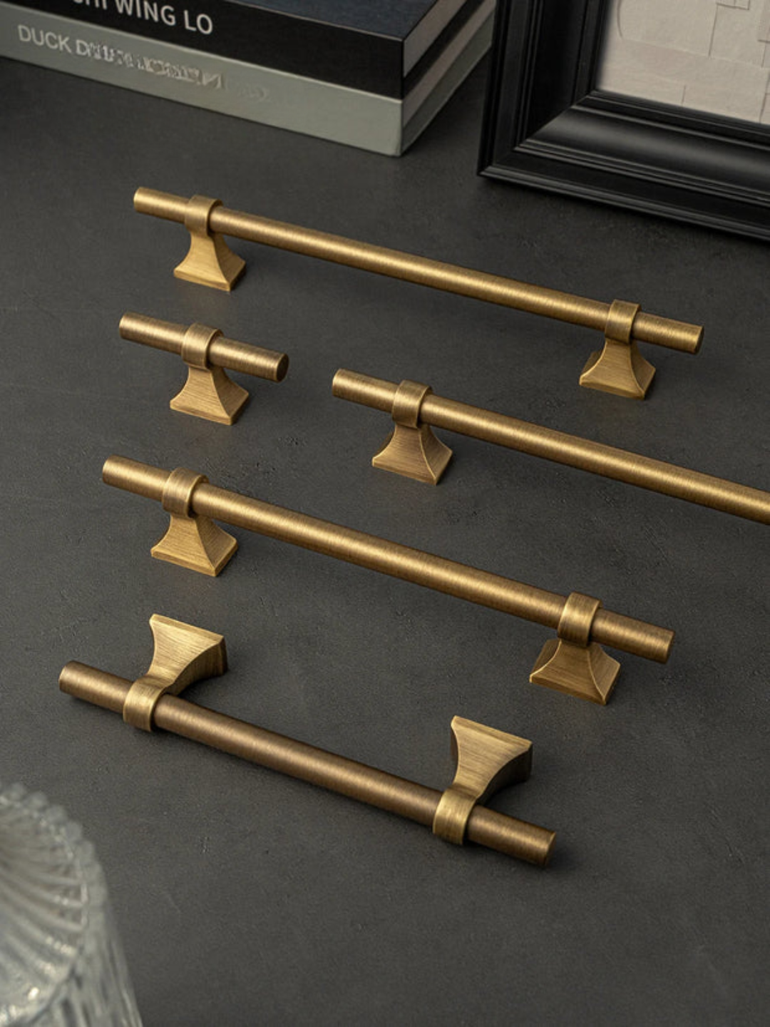 Set of gold cabinet handles on a dark surface
