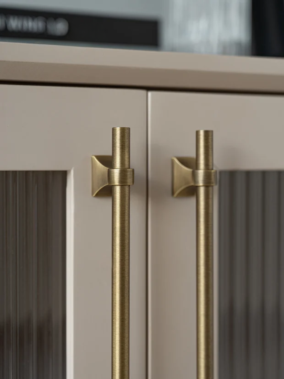 Close-up of a kitchen cabinet with gold handles on a blurred background