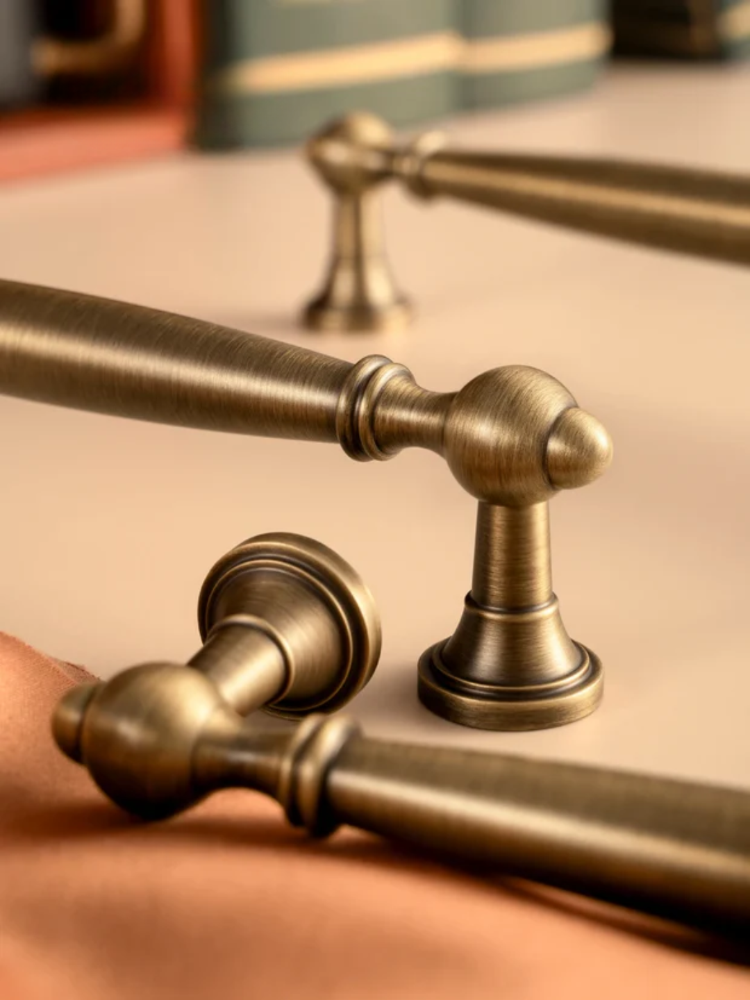 Close-up of vintage-style brass towel bars on a textured surface.