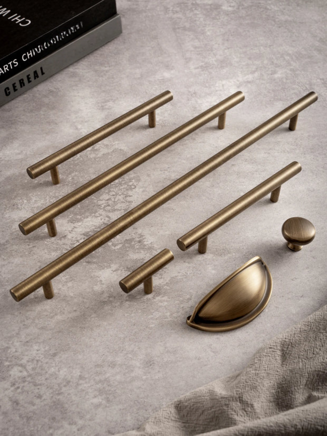 Set of brass cabinet handles and knobs on a gray surface