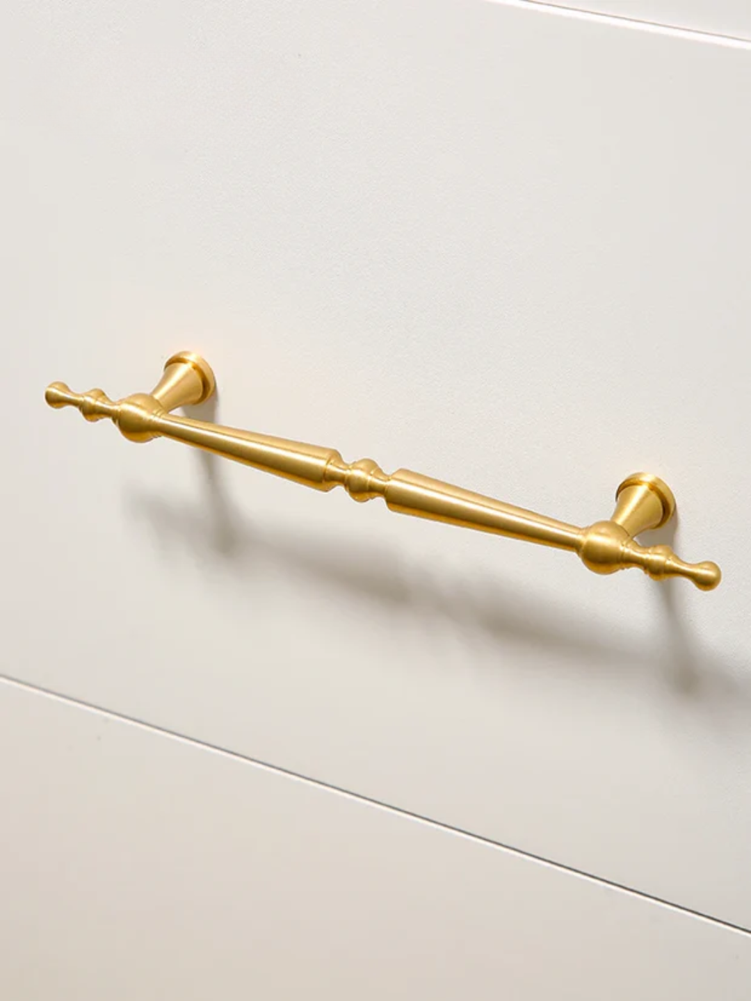 Gold cabinet handle on a white cabinet