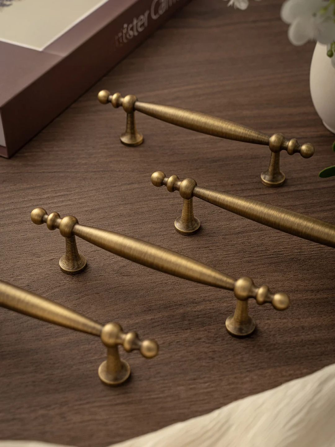 Set of brass cabinet handles on a wooden surface