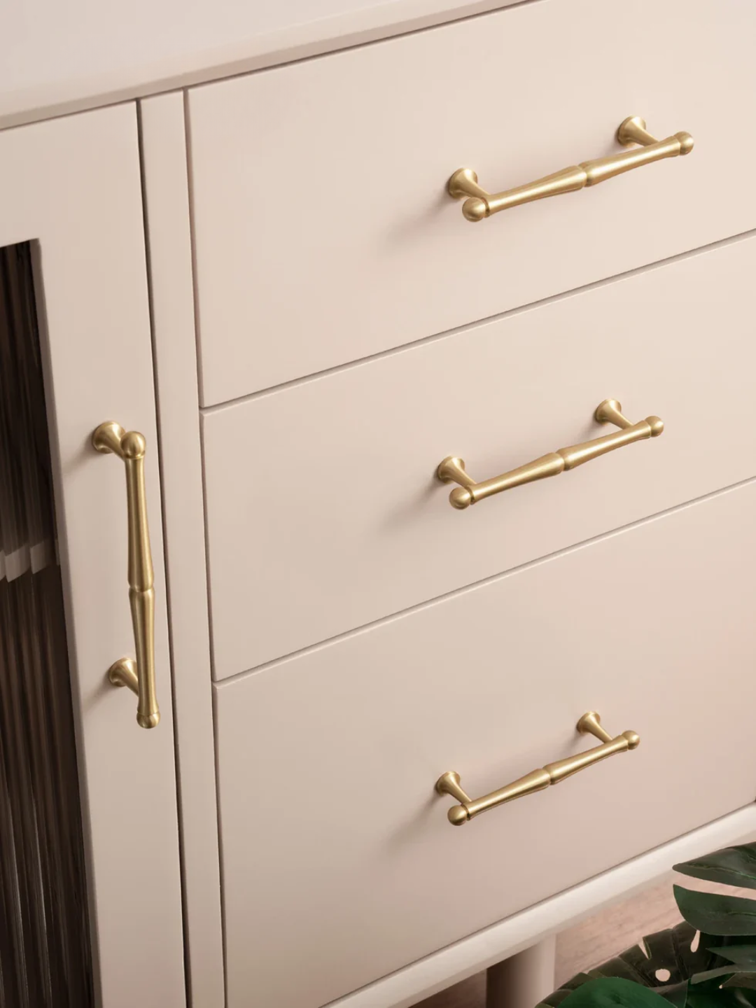 Close-up of a light-colored cabinet with gold handles