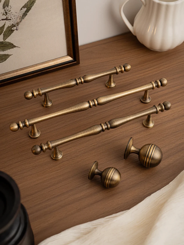 Set of gold cabinet handles on a wooden surface with a blurred background