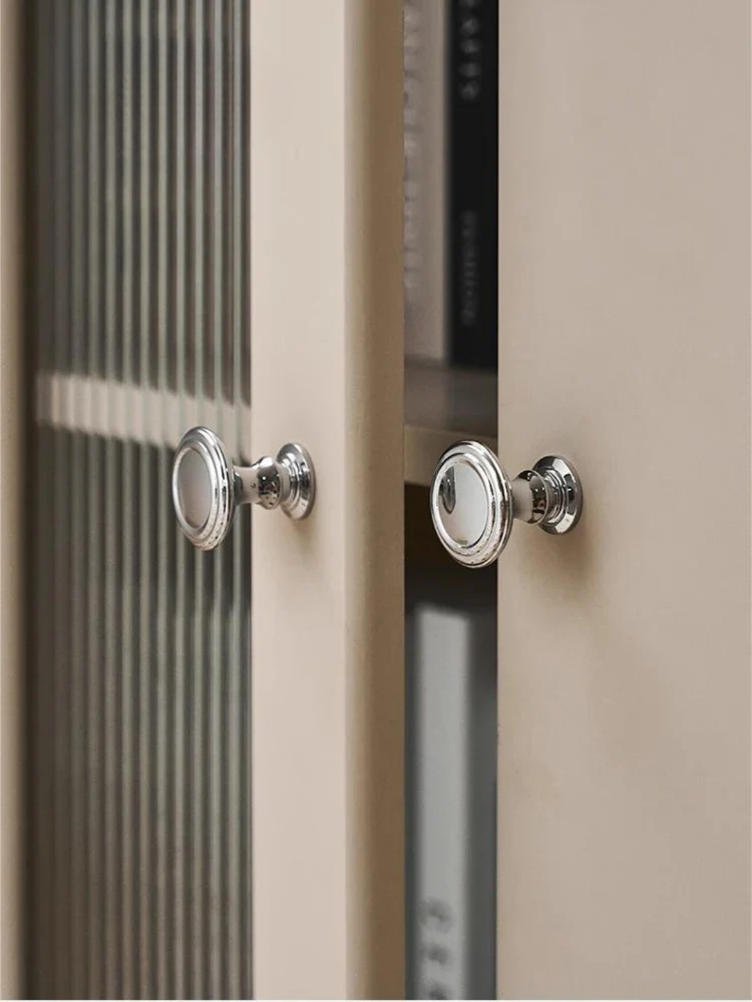 Close-up of a cabinet with glass doors and metallic handles.