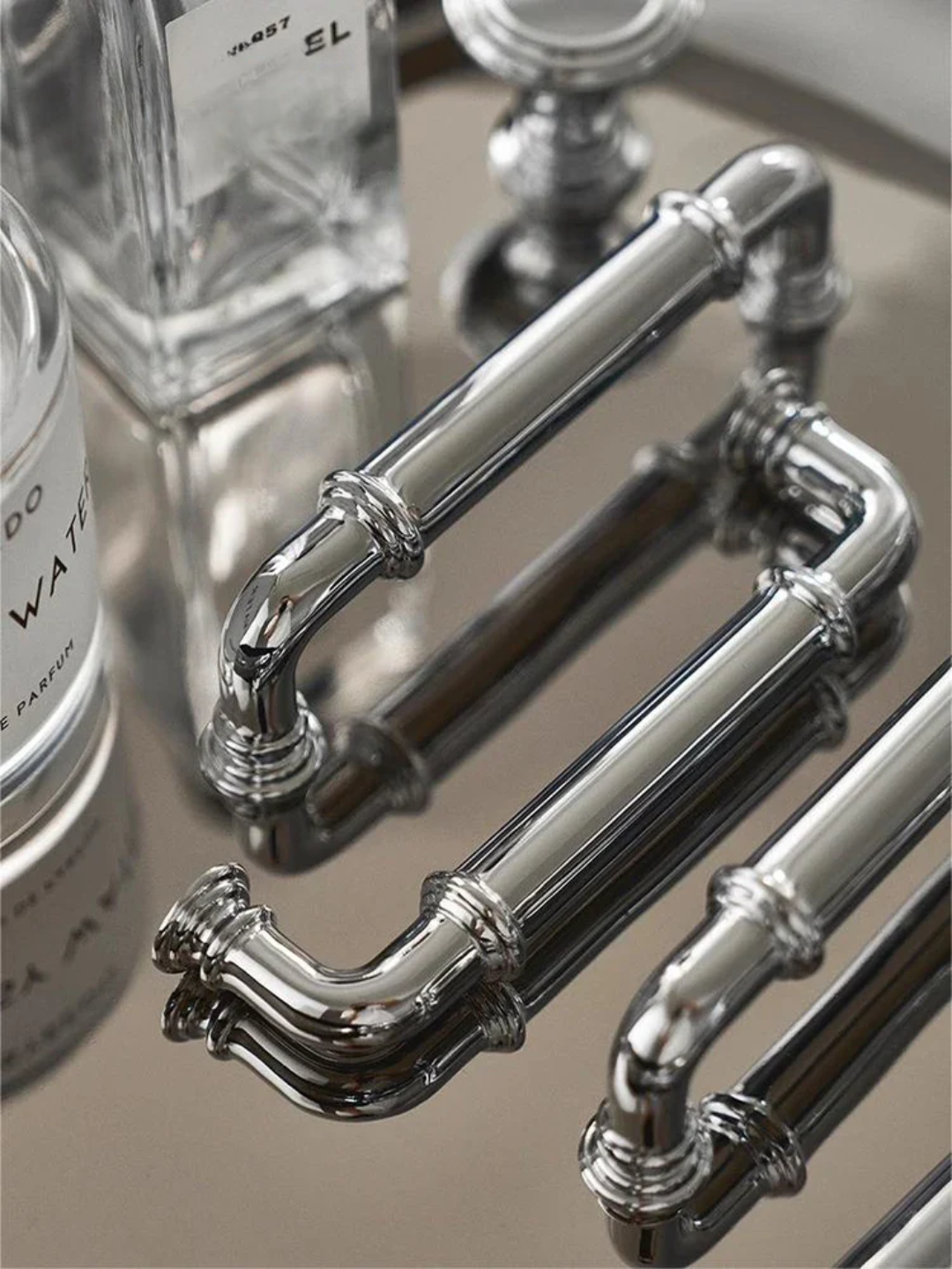 Close-up of decorative silver pipes on a reflective surface