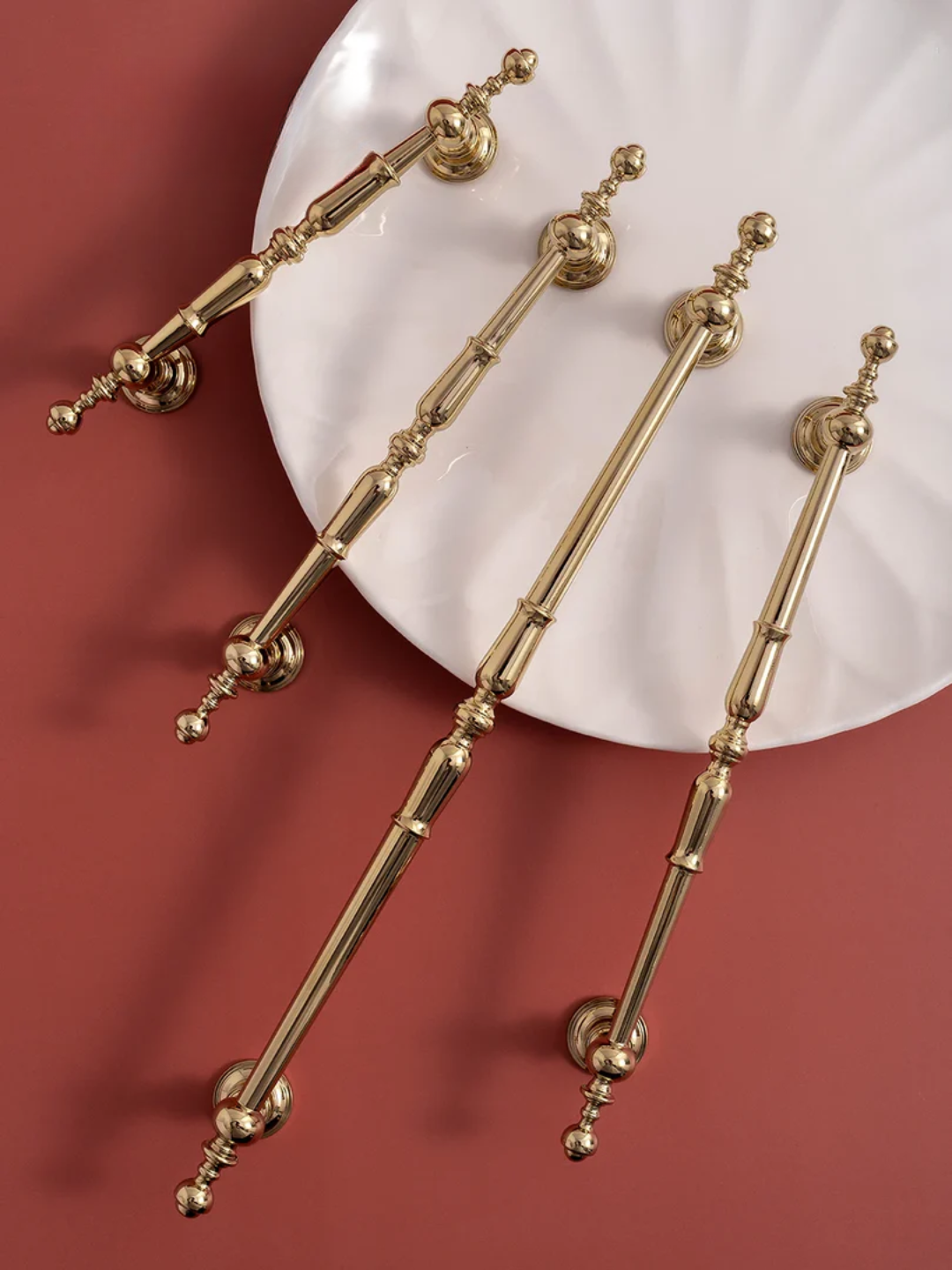 Set of gold decorative elements on a white plate against a red background