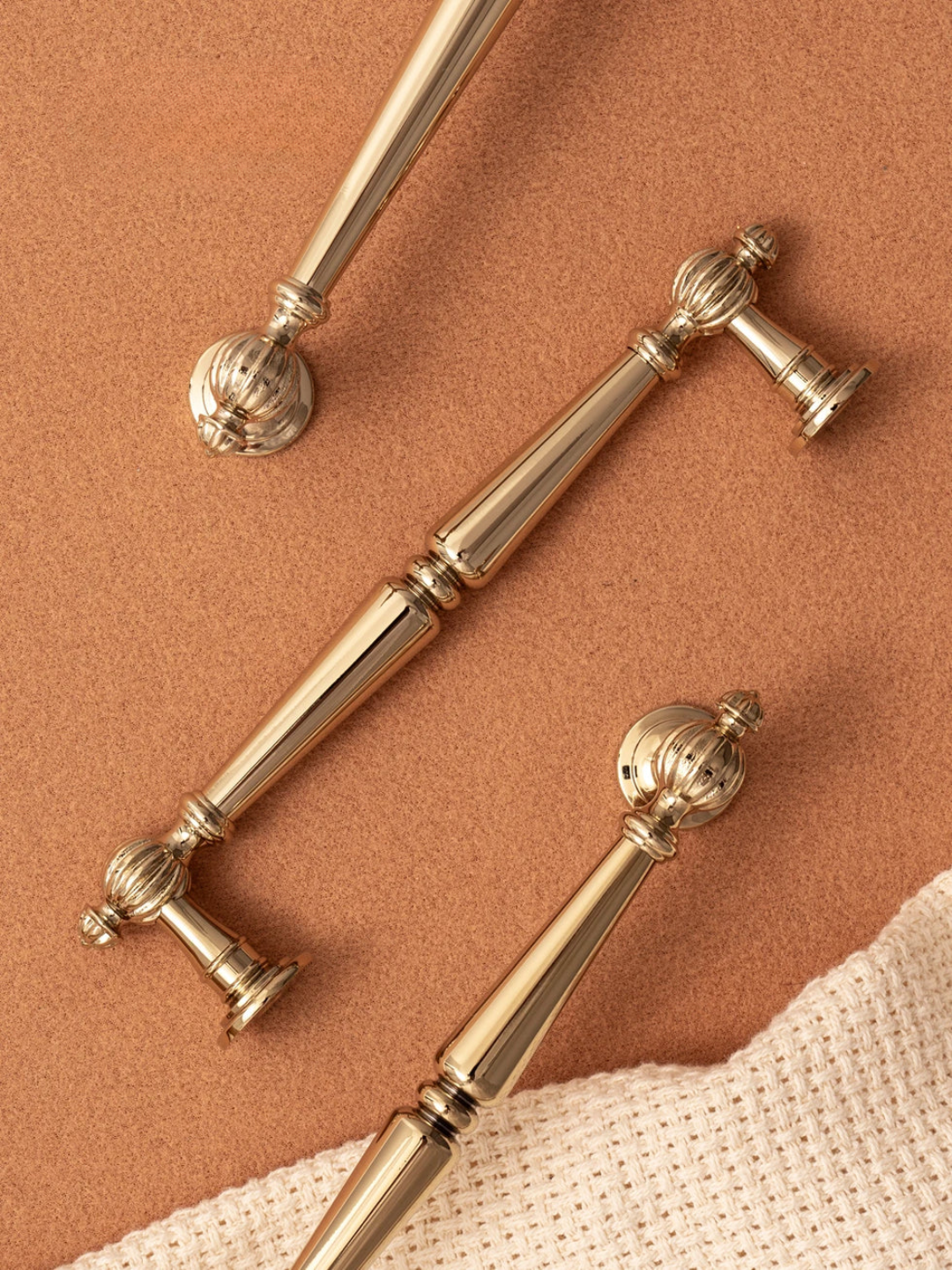 Three gold cabinet handles on a brown surface