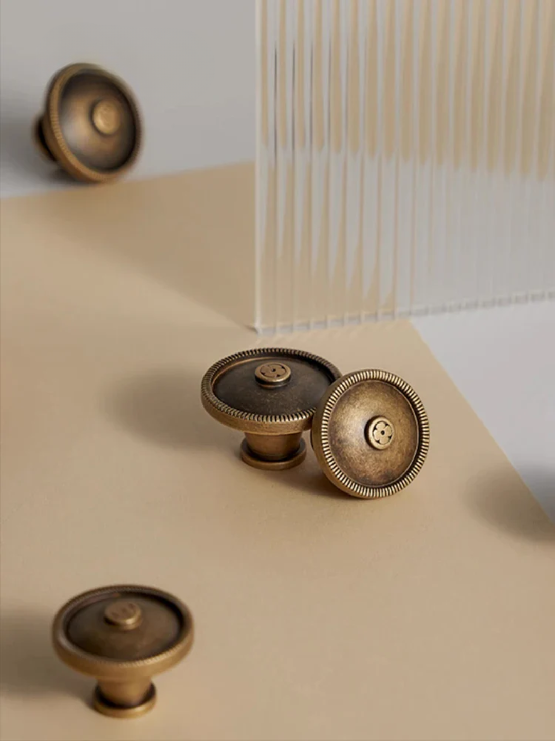 Bronze cabinet knobs on a beige surface with a white background