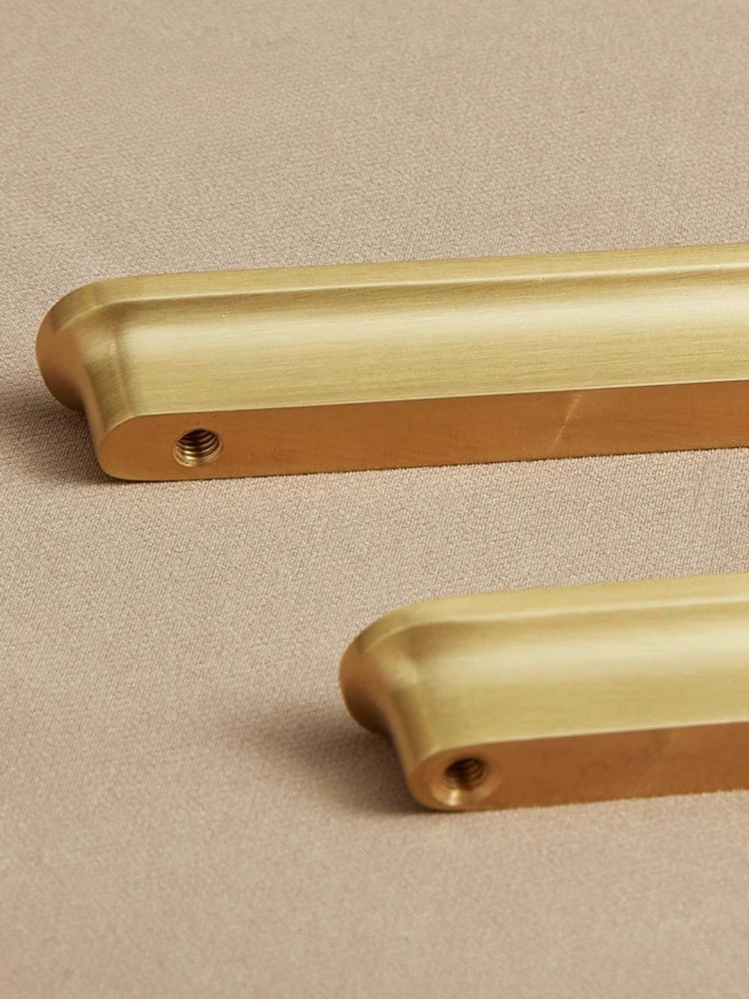 Two gold handles on a beige background