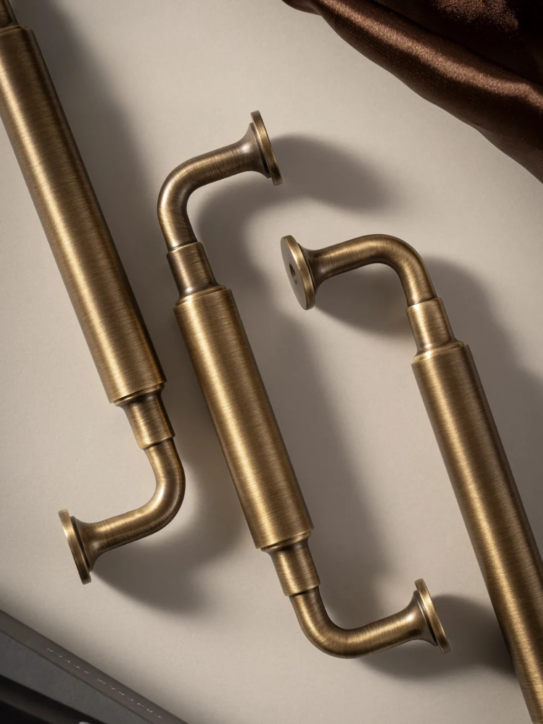 Pair of brass handles on a neutral background