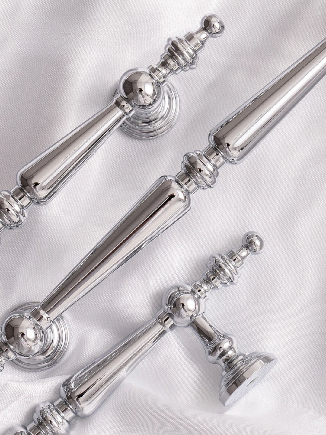 Silver decorative finials on a white background