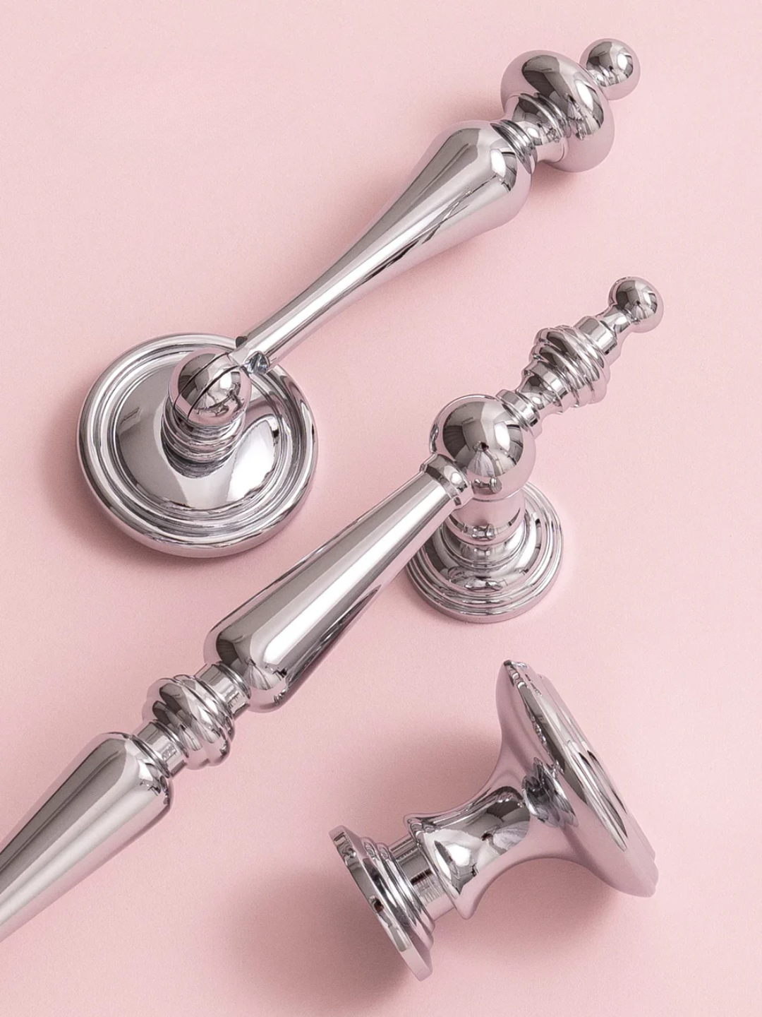 Silver door handles on a pink background