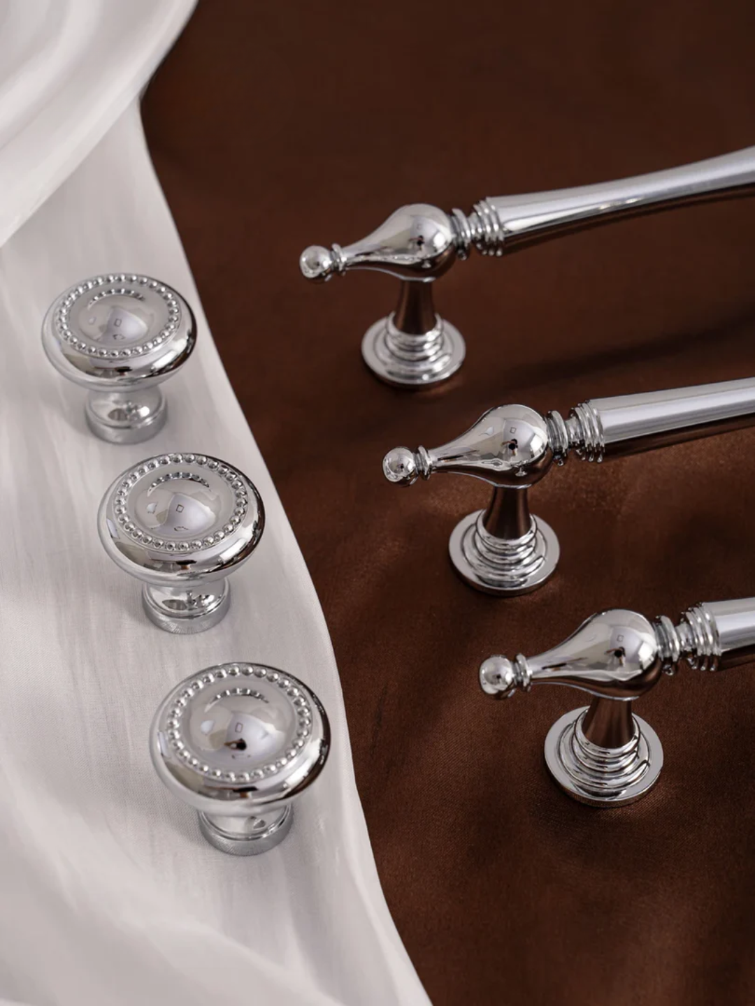 Silver cabinet knobs and handles on a wooden surface