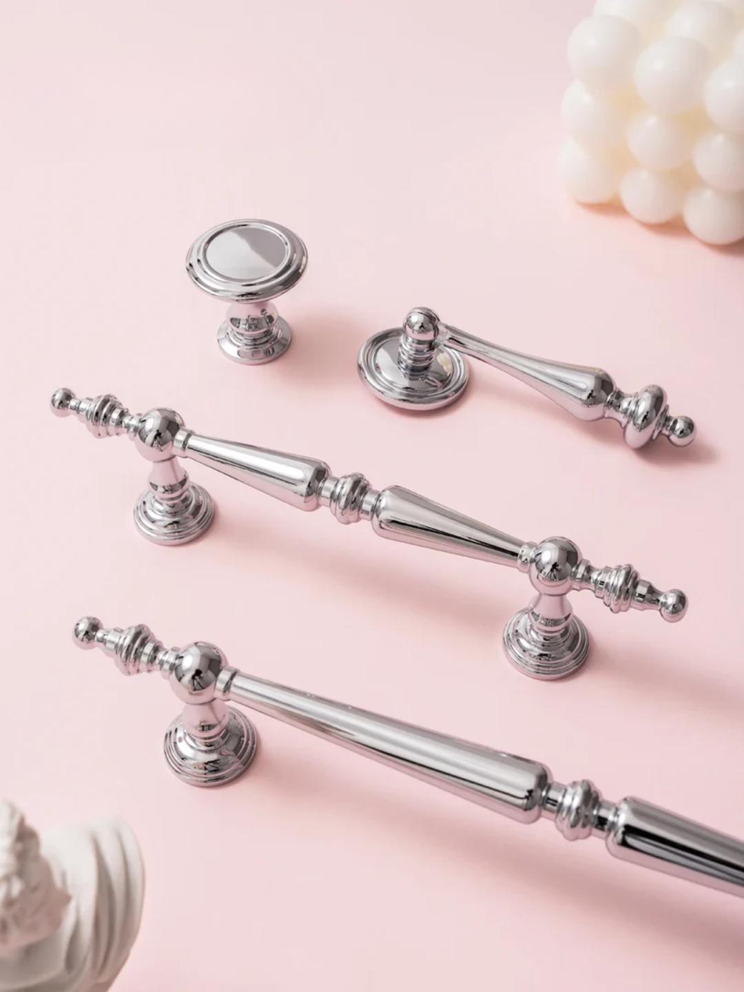 Set of silver cabinet handles on a pink background