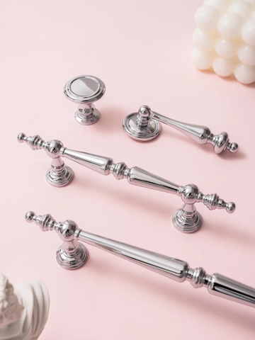 Set of silver cabinet handles on a pink background