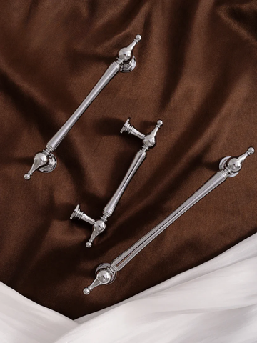 Silver decorative elements on a brown and white fabric background