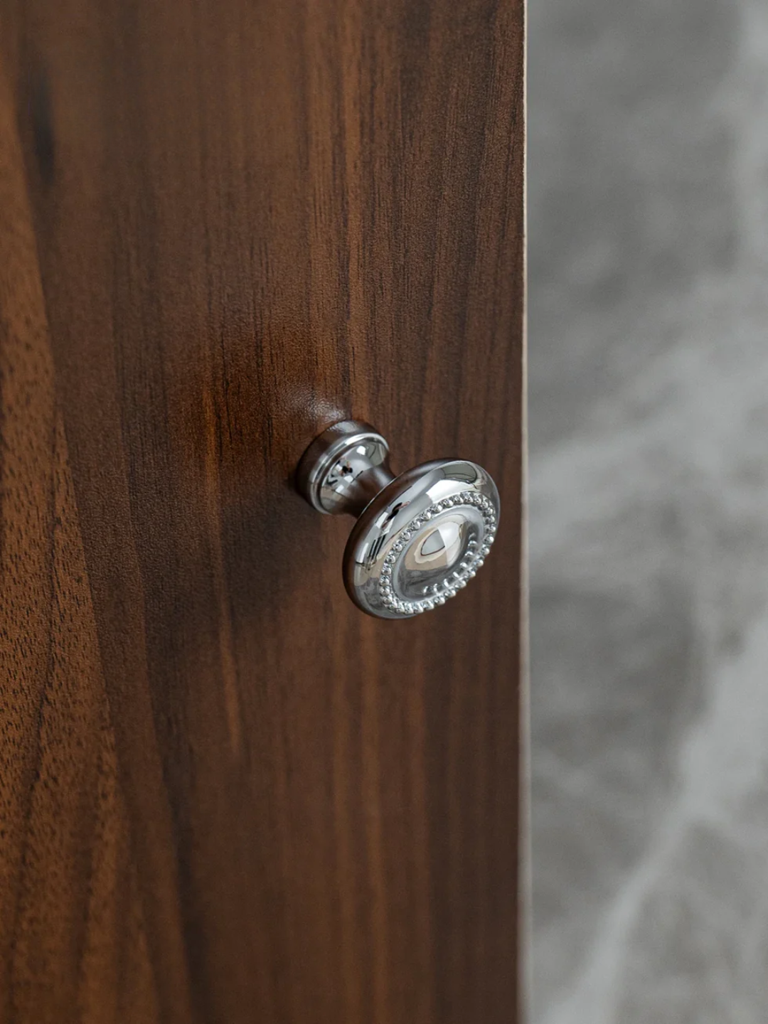 Wooden door with a silver doorknob on a blurred background